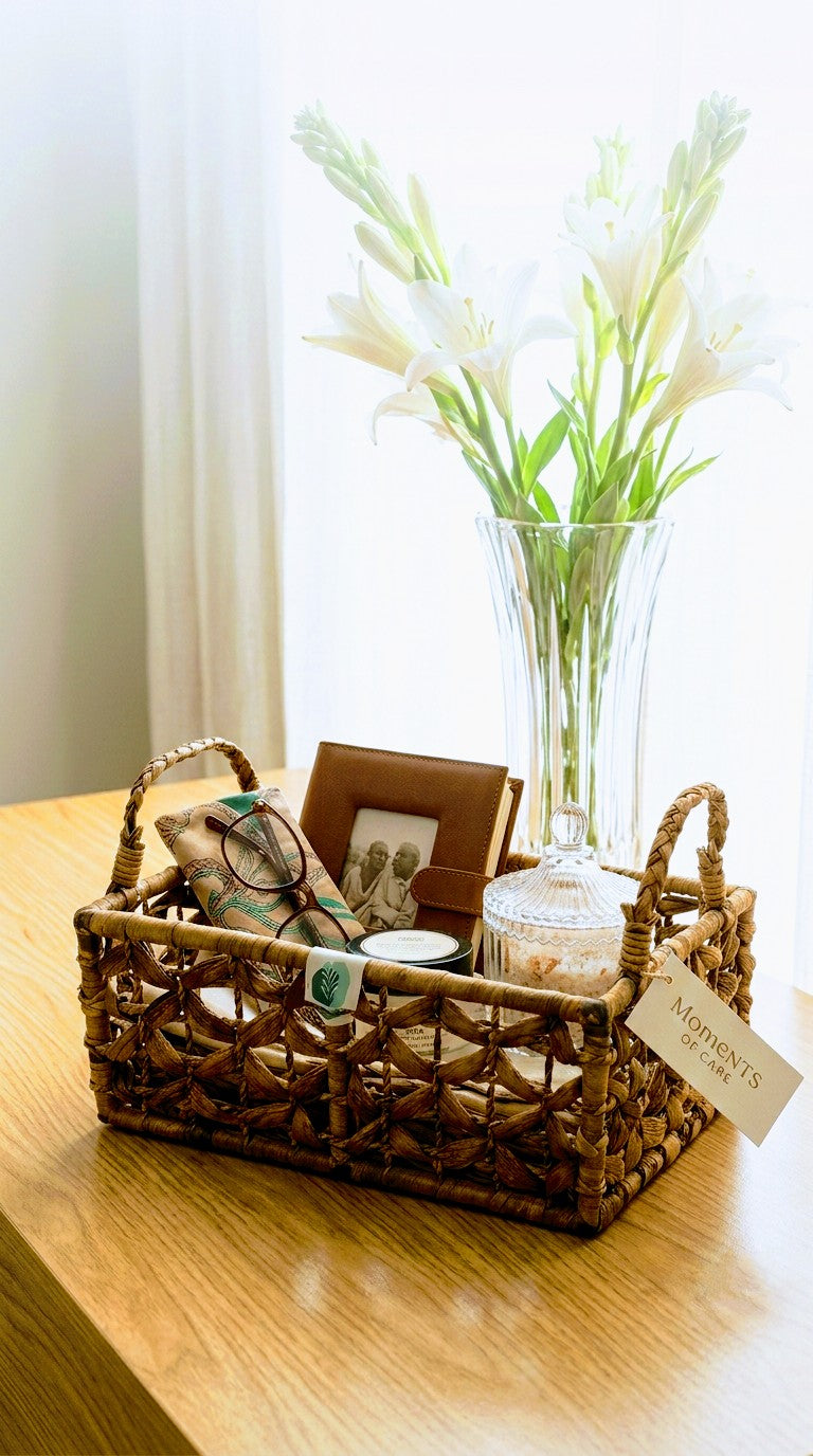 Hand woven water hyacinth basket with handle with decorative items on a wooden surface